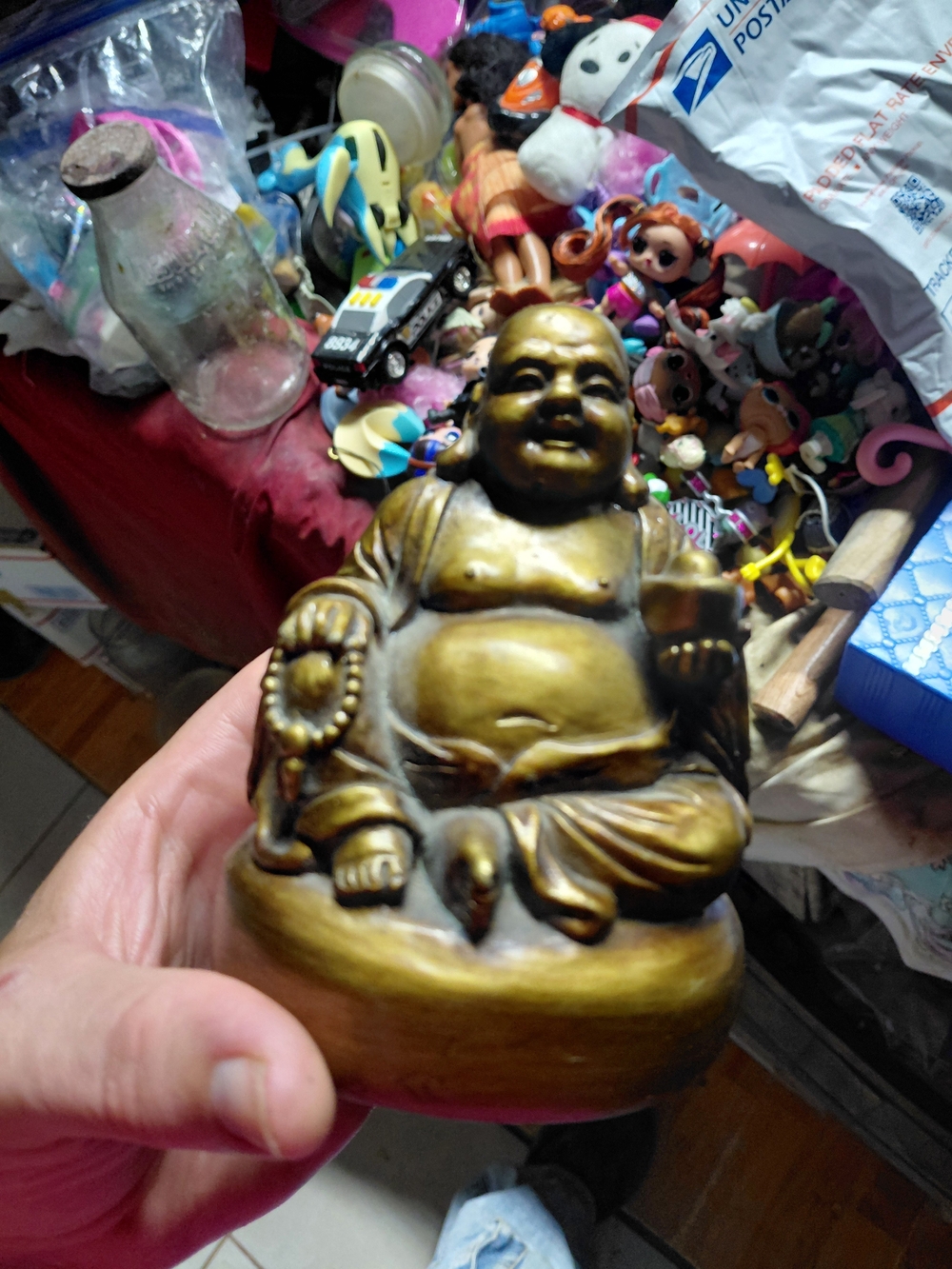 gold-toned figurine of the Laughing Buddha (Budai) holding prayer beads and a we